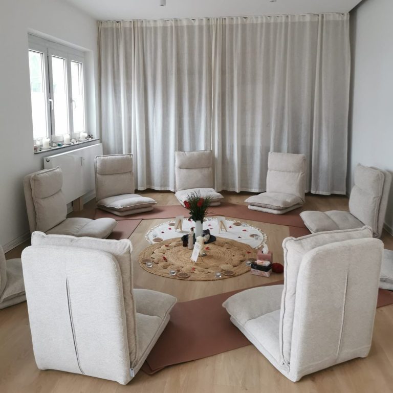 Petra & Vanessa Zwei Frauen lächeln in einem sonnendurchfluteten Raum, eine trägt ein oranges Hemd.